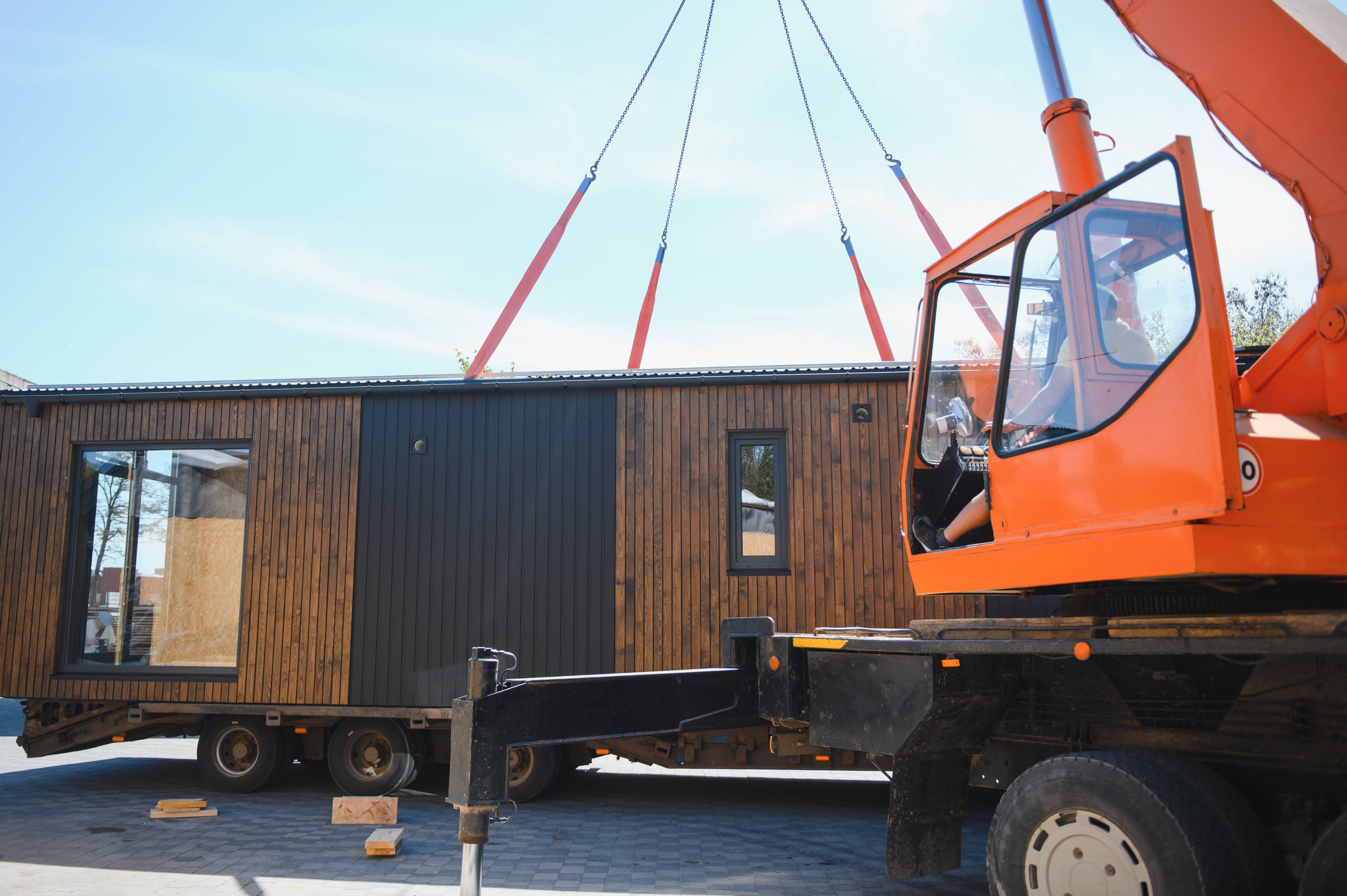 stock-photo-crane-operator-lifting-prefabricated-modular-house-onto-truck-showcasing-efficient-construction-2654472693